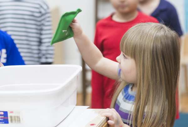 Girl placing beanbag in bin